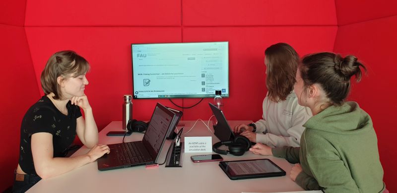 3 Studentinnen vor dem Team-Monitor